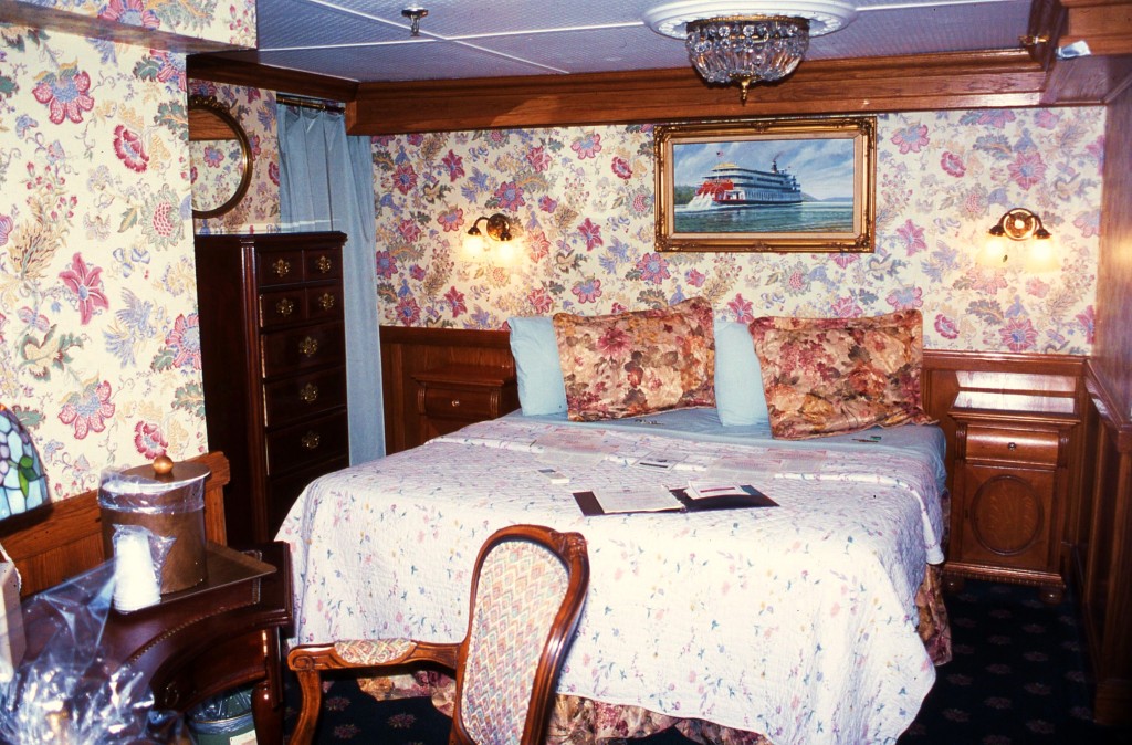 A stateroom aboard the AMERICAN QUEEN with a reminder of her predecessor DELTA QUEEN seen in the painting above the bed. * Photo: Ted Scull