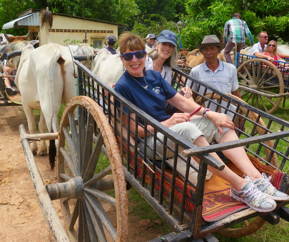An ox cart ride through the Cambodian countryside with other AmaDara passengers in 2018. Anne Kalosh is in the blue cap scaled 1