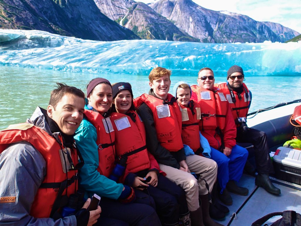 Family on a skiff near a glacier