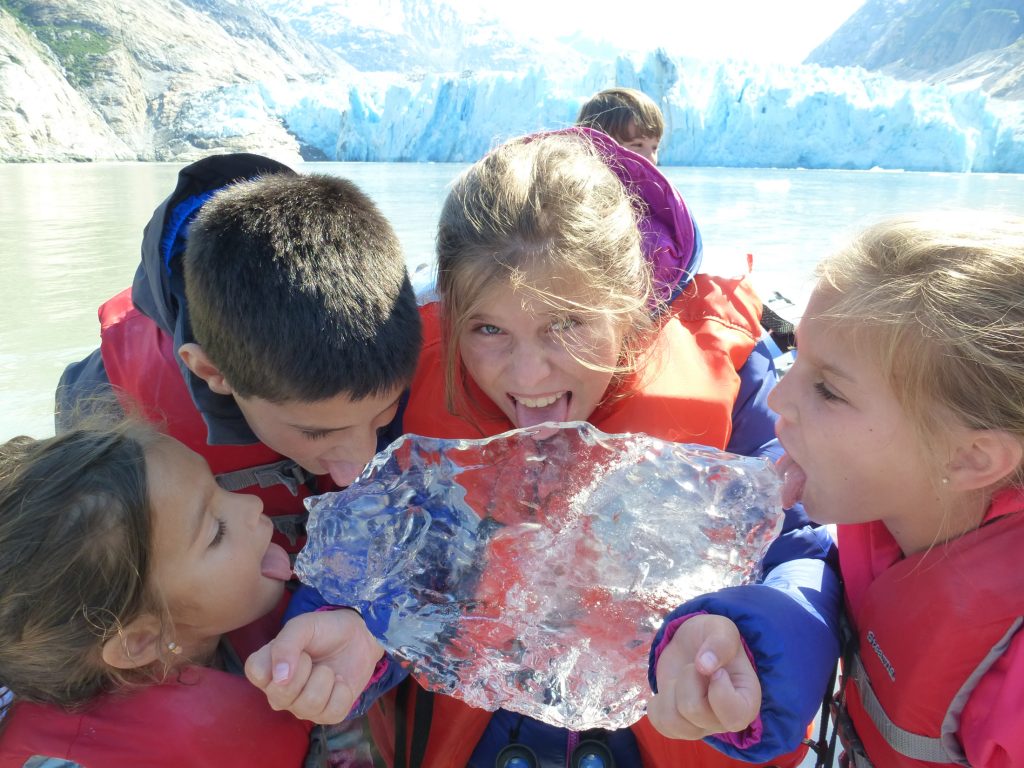 Kids tasting an iceberg in Alaska
