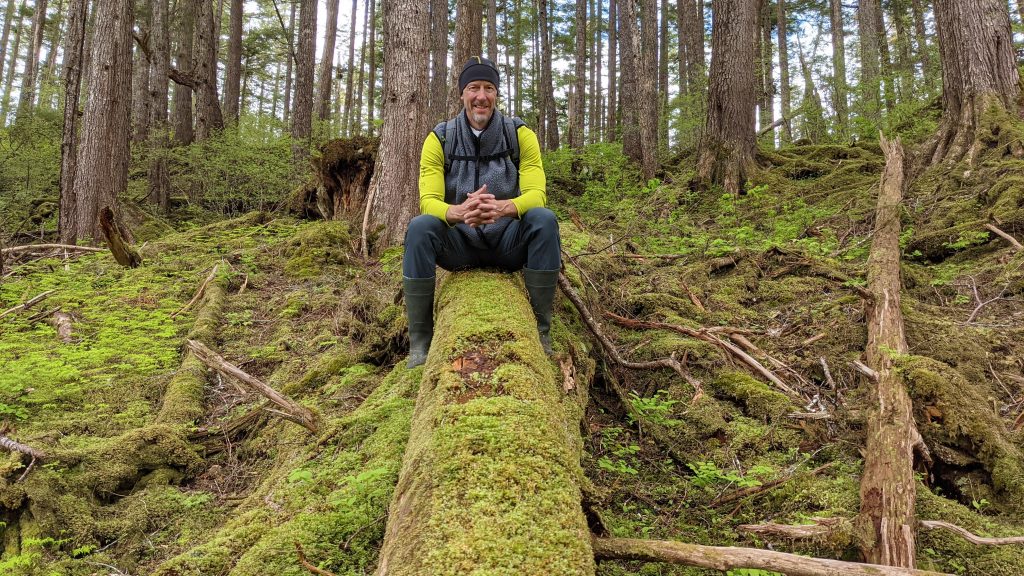 John on a fallen tree in Alaska with UnCruise