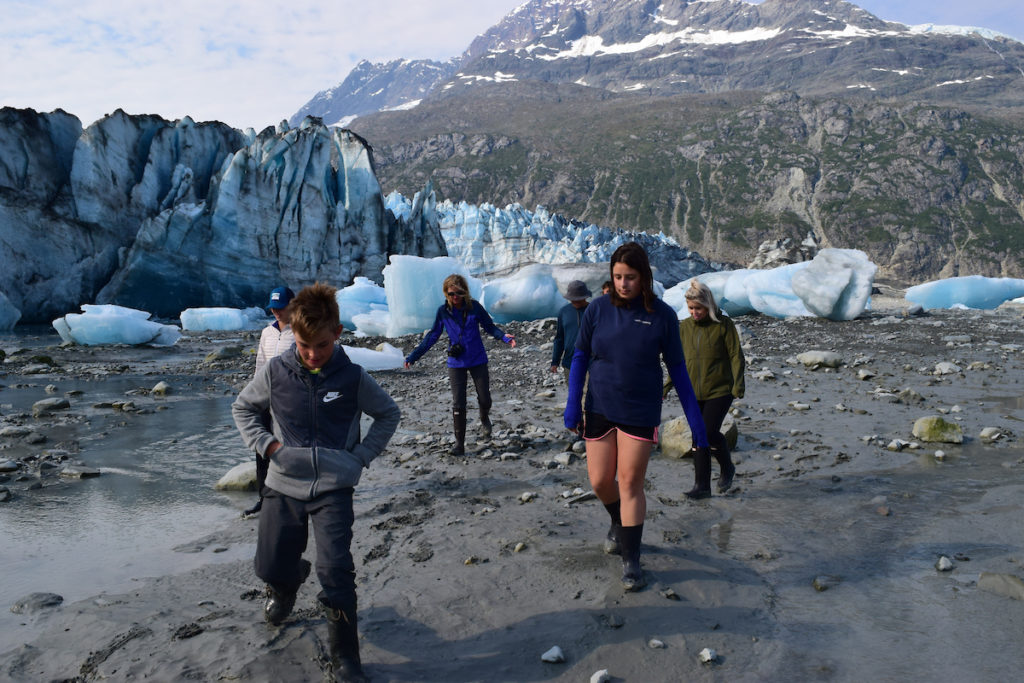 Family on shore walk by Lamplugh Glacier