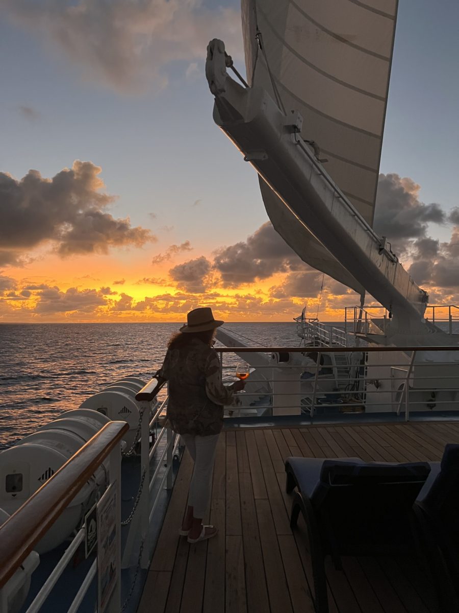 Windstar Tahiti cruise review author Judi cohen enjoying Aperol Spritz at sunset on Wind Spirit