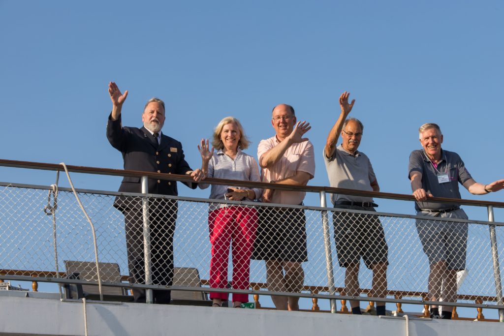 Cruise Director Trevor Houle & passengers waving from deck