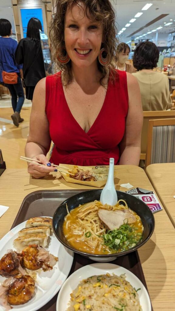 Colleen facing a delicious spread of ramen and Takoyaki in Nagasaki