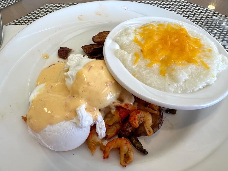 Poached eggs with crawfish hash and cheesy grits for breakfast on an Mississippi River cruise with ACL