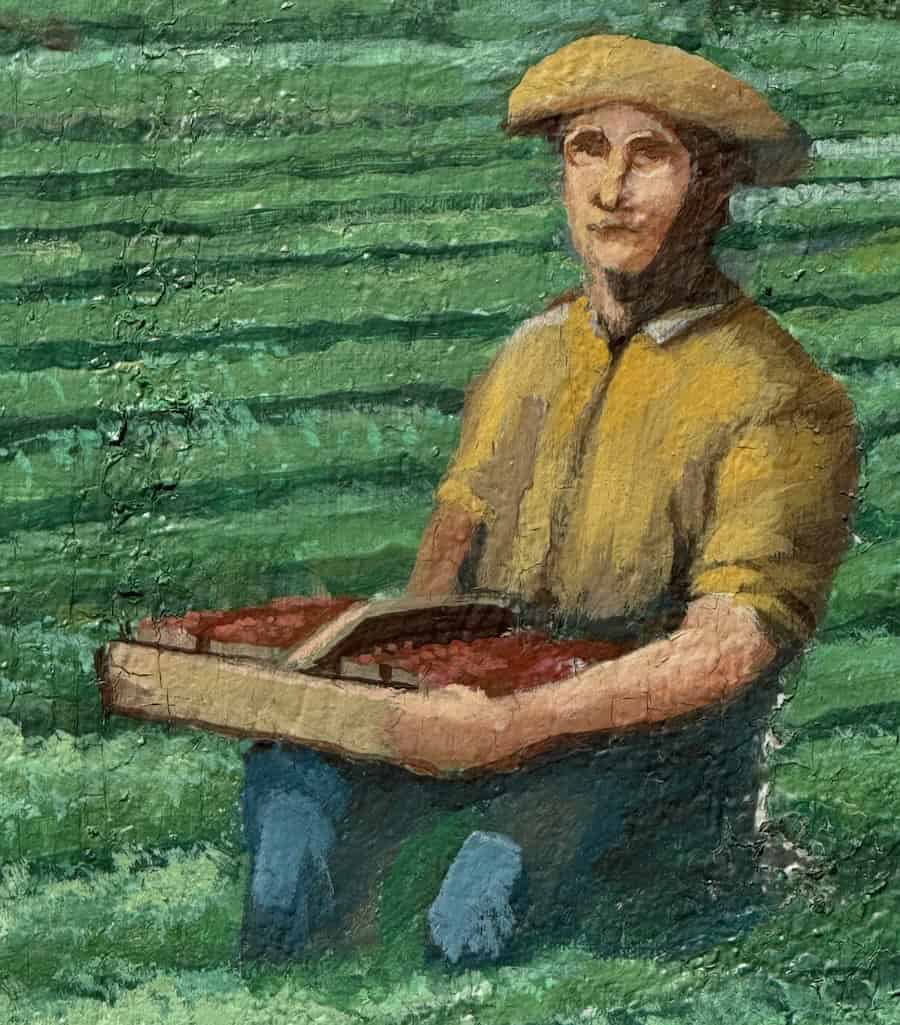 John Lennon sits in a strawberry field on the floodwall mural