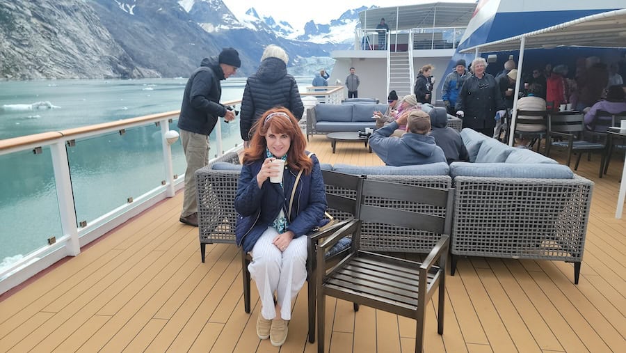 enjoying hot chocolate on deck of an America Cruise Lines Alaska