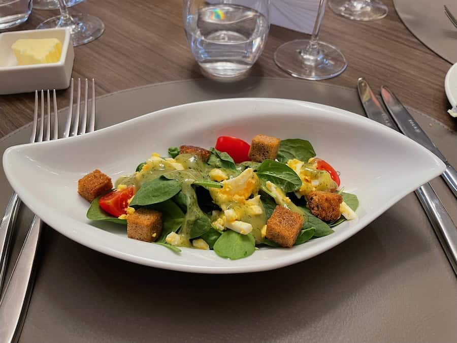 A tasty spinach salad in the Riverside Dining Room on a Rhine & Moselle Cruise Aboard Riviera Resplendence includes