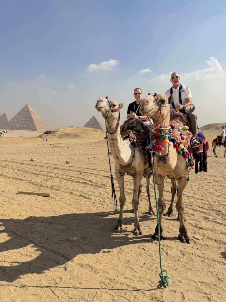 Riding camels at the Great Pyramids in November 2025 during a trip led by Michael Consoli, left (Photo courtesy Cruise Planners)